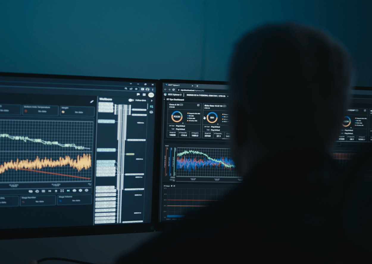 Man sitting in front of computer showing graphs